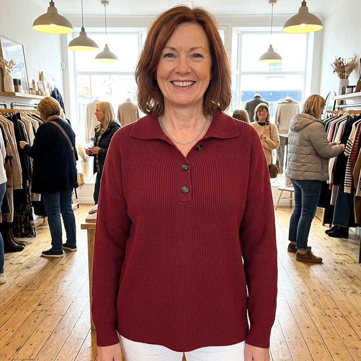 Constance polo-collar button jumper in Burgundy, worn in a boutique