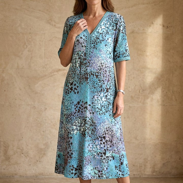 Iris flowing midi dress in Blue, against a stone wall